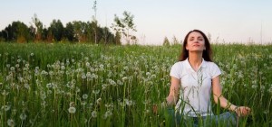 WomanMeditatingInDandelionField-850x400